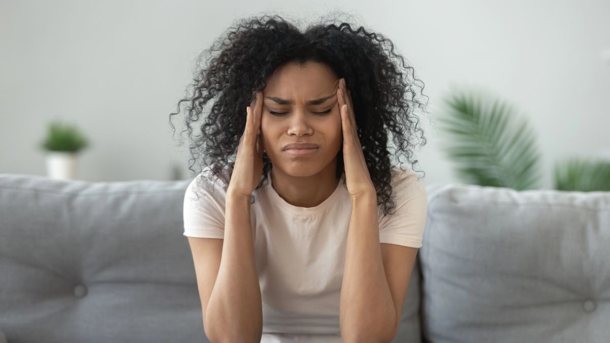 woman with headache on couch