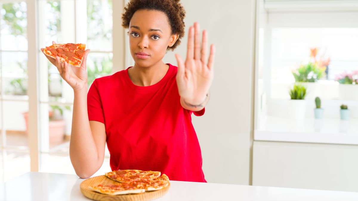 woman with pizza showing stop