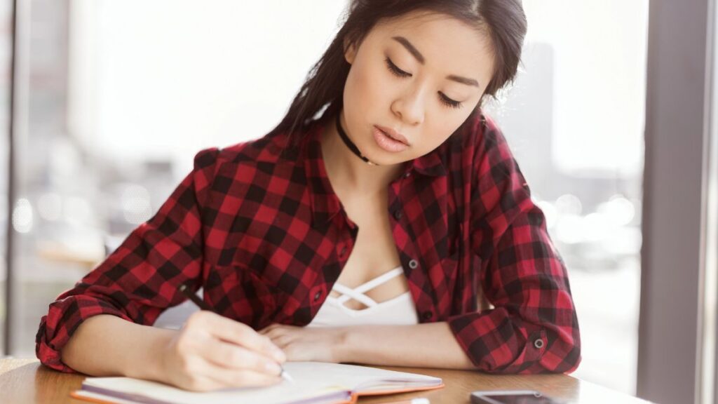 woman writing in book