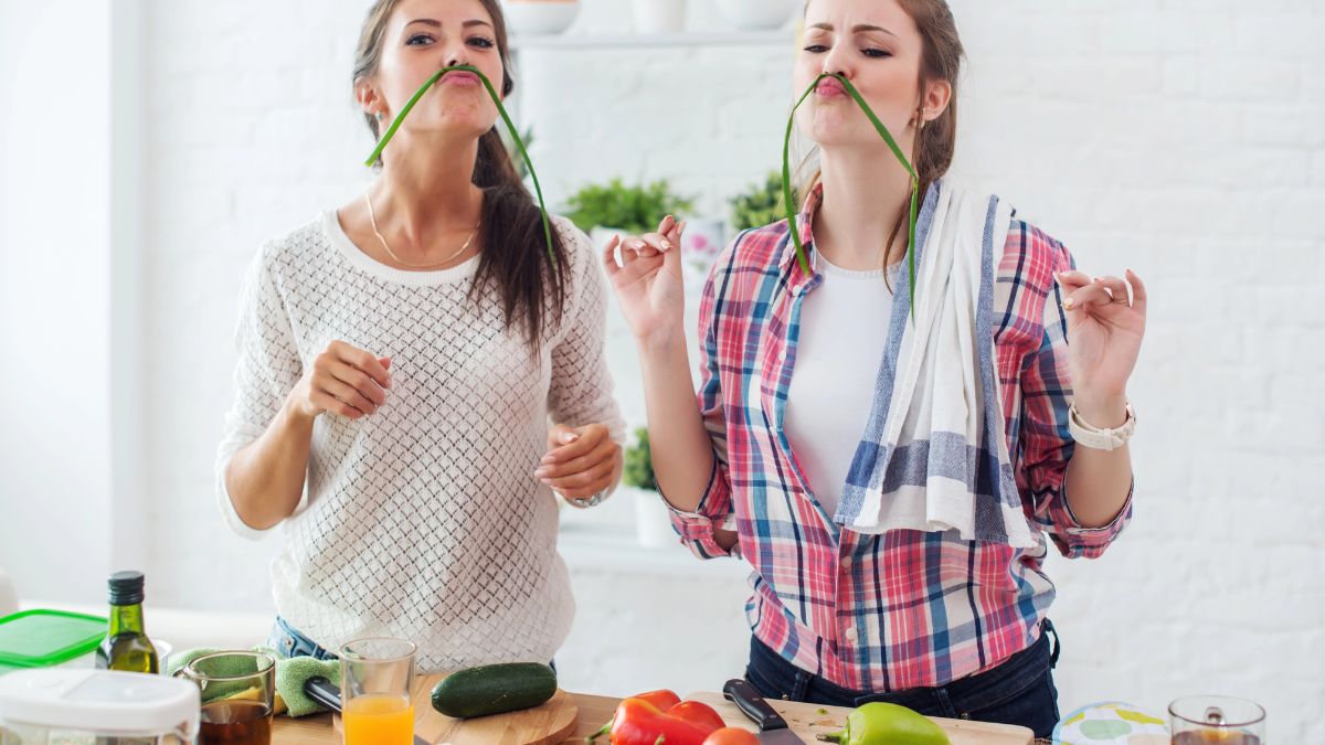 women in kitchen with chives on face