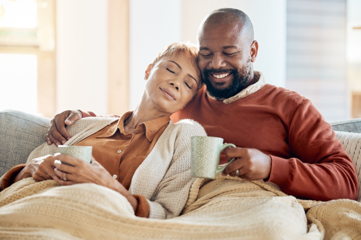 Black couple relax on sofa with coffee