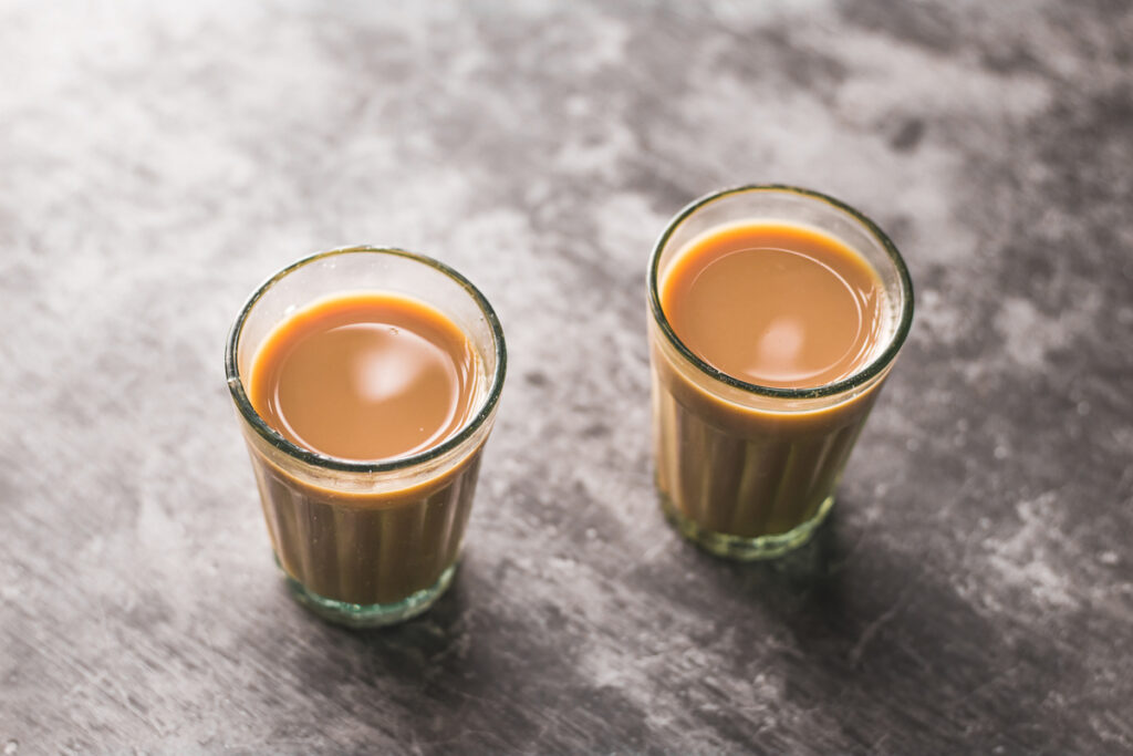 The Indian chai in glass cups with masalas to make the tea.