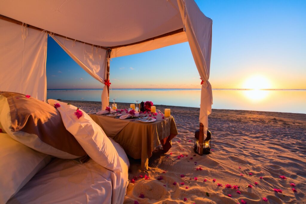 Romantic luxury dinner setting at tropical beach on sunset