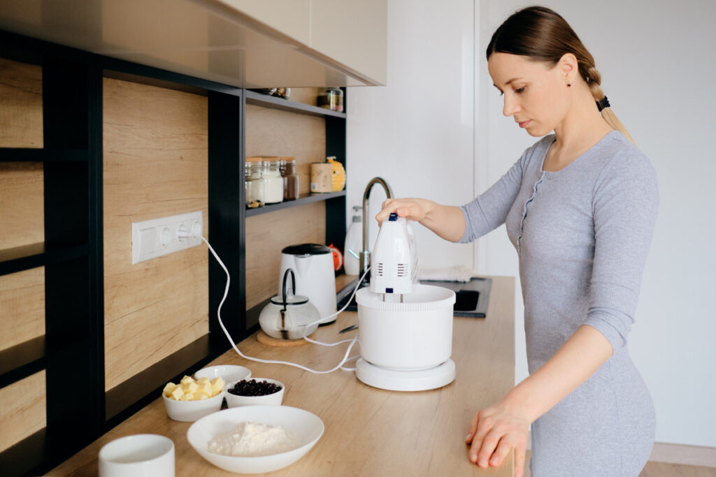 woman using a handheld mixer