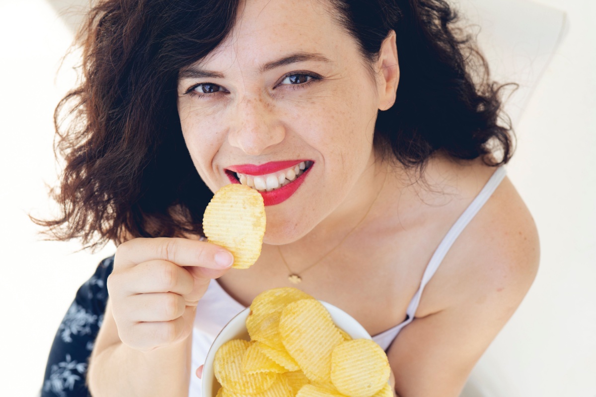 beautiful woman eating potato chips