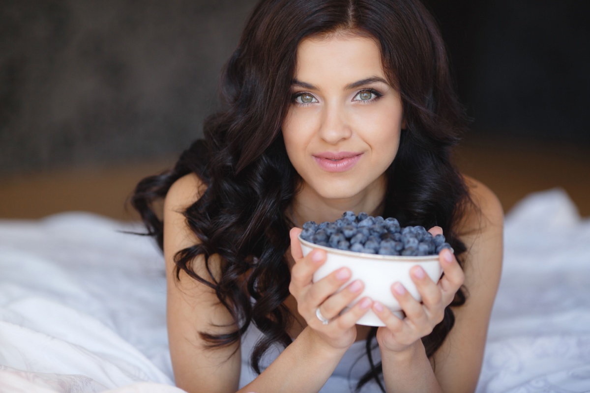 beautiful woman holding bowl of blueberries fruit