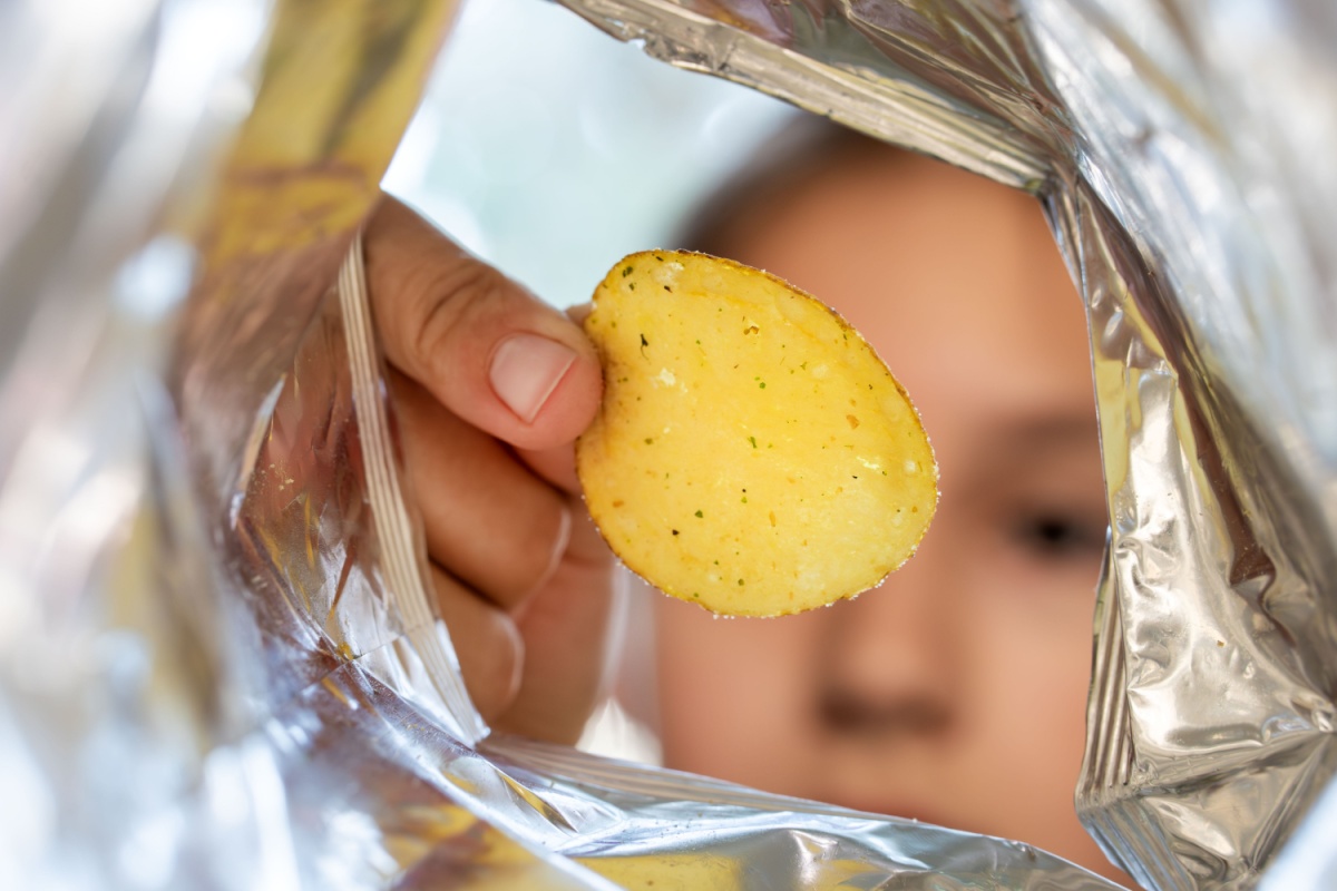 eating unhealthy potato chip out of bag