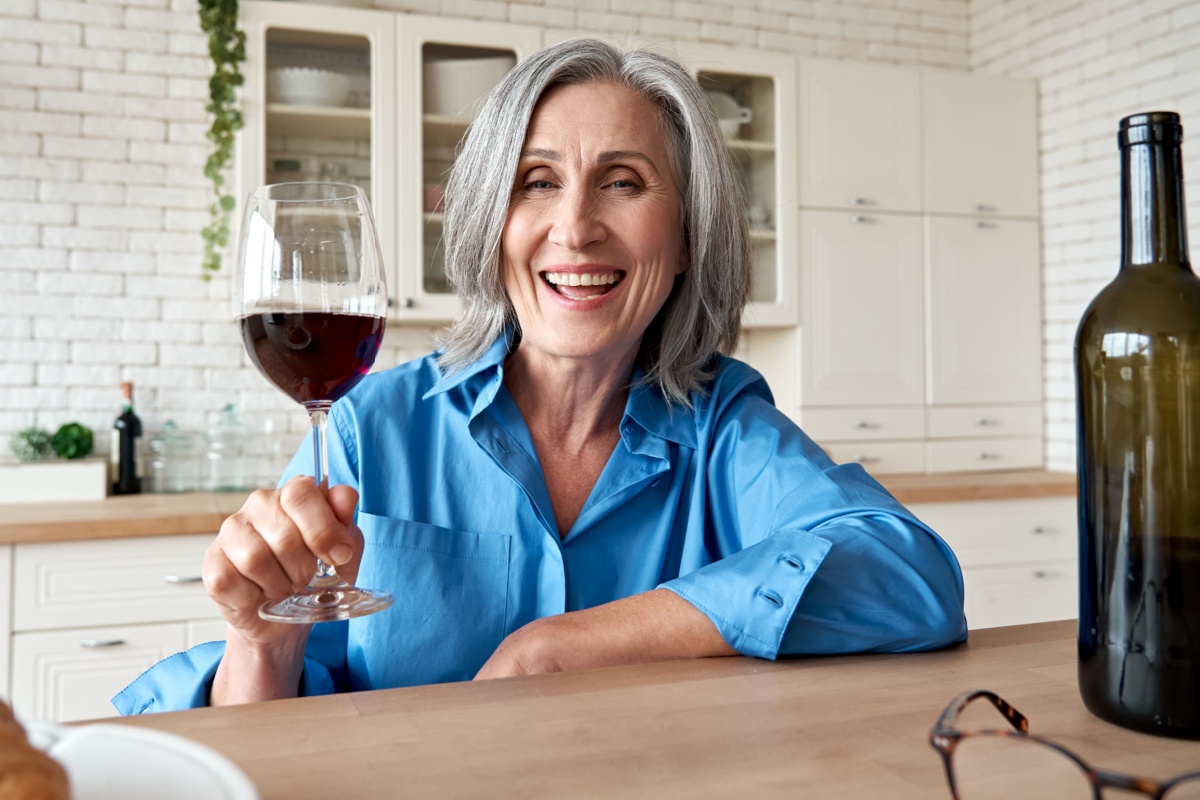 happy mature senior woman drinking glass of wine