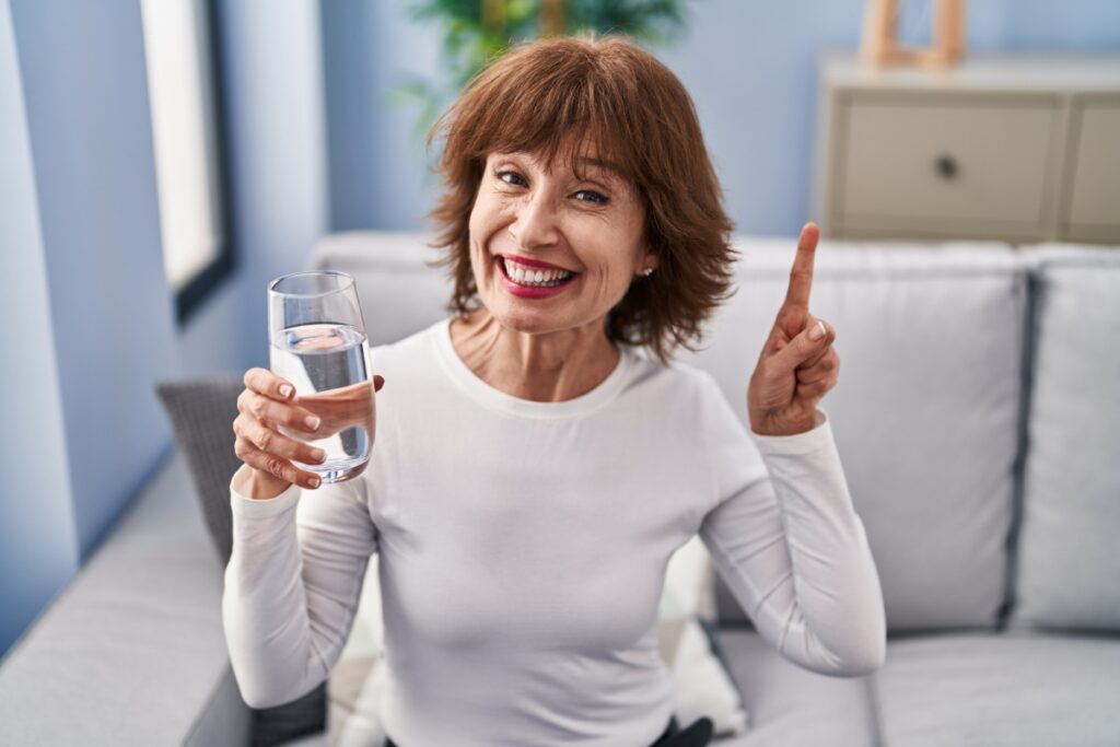 happy middle aged woman drinking water