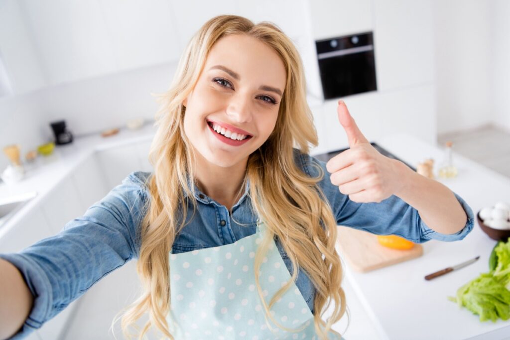 happy woman in kitchen thumbs up reaction