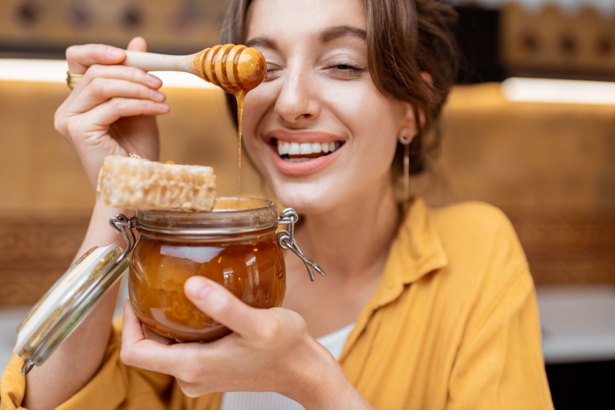 happy woman with honey and honeycomb