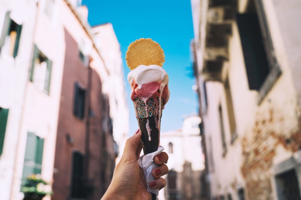 italian gelato in waffle cone in front of streets and bridges of Venice