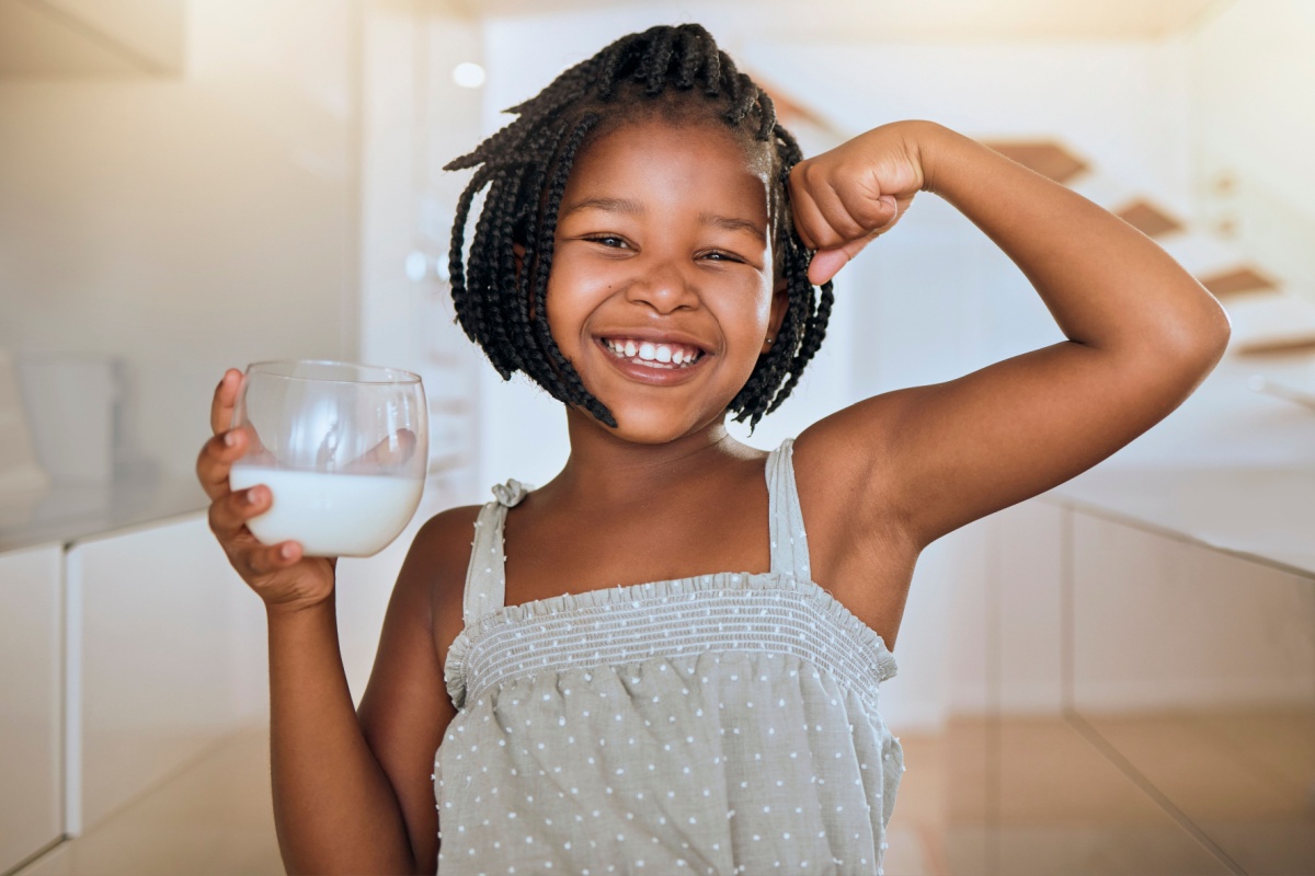 little girl flexing muscle with milk