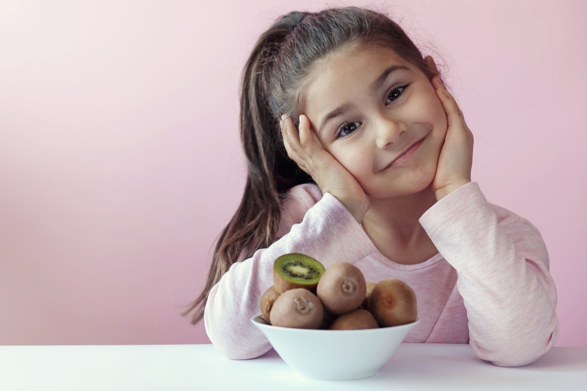 little girl with bowl of kiwi fruit