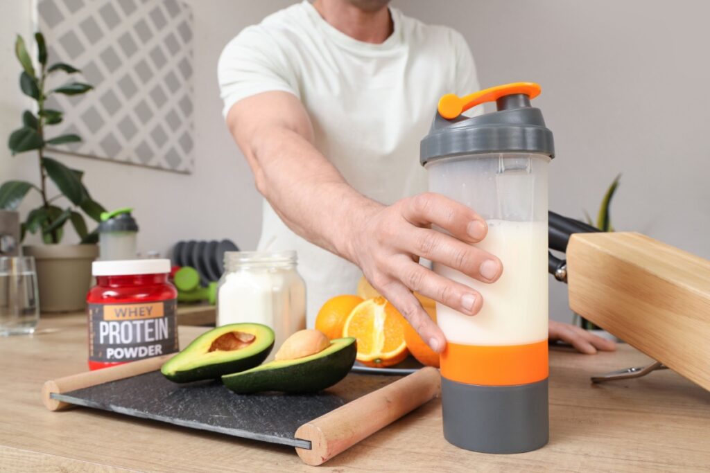  man with protein shake on table in kitchen