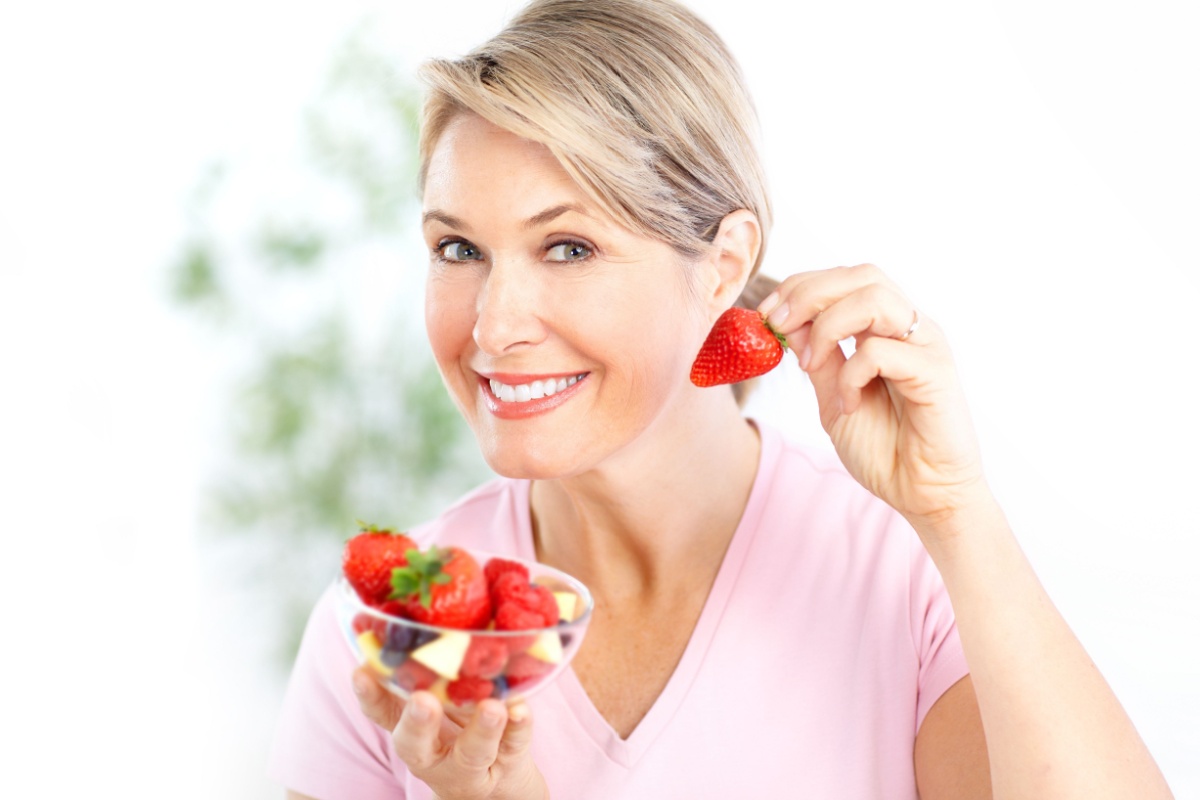 mature woman eating berries strawberry