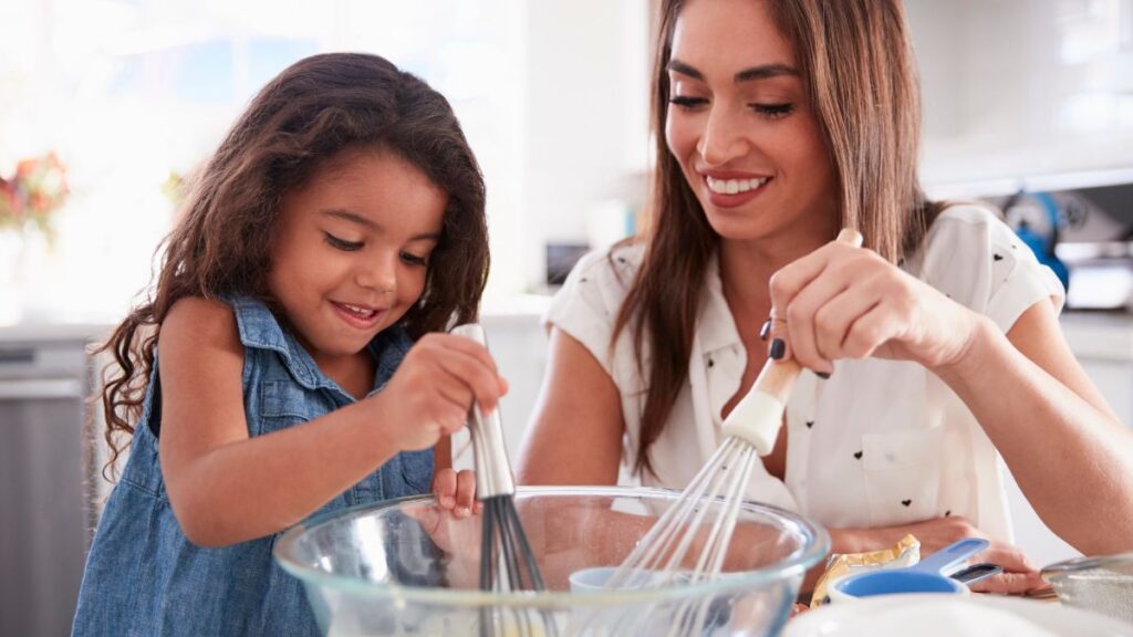 mom and daughter mixing cake mix