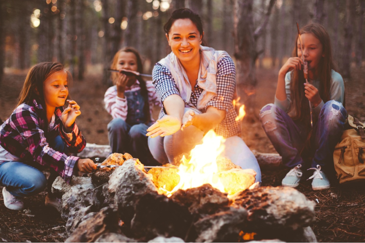 mom and kids sitting around campfire