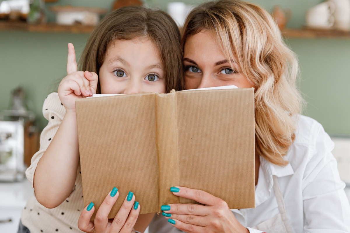 mom daughter baker looking over cook book idea