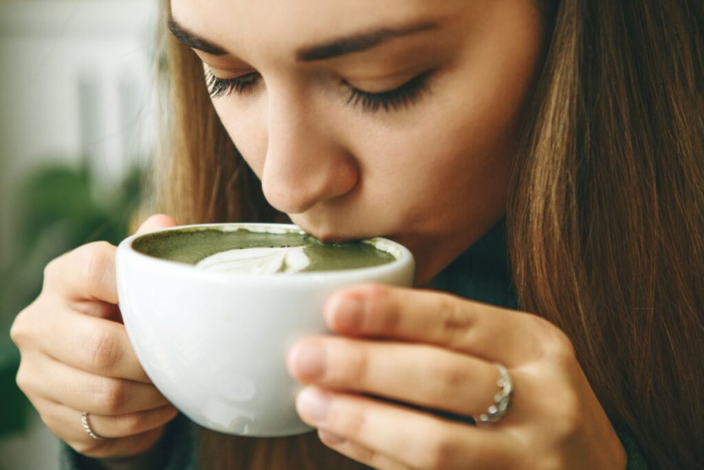 woman drinking green matcha latte tea