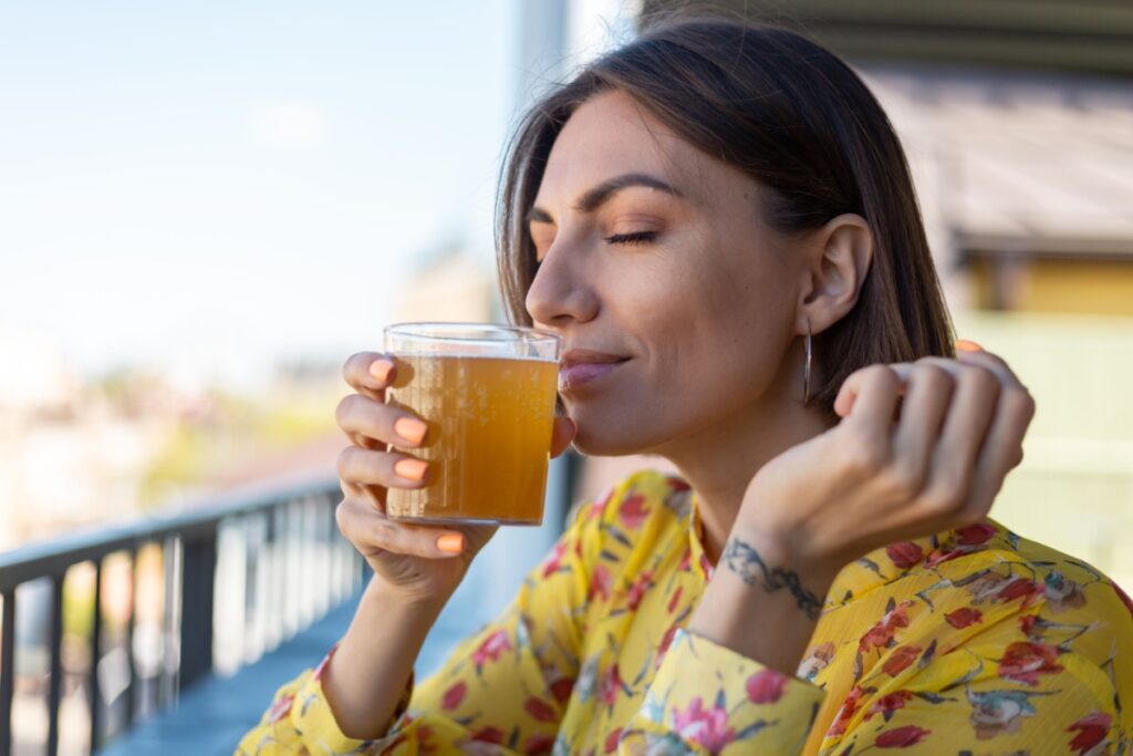 woman drinking kombucha glass