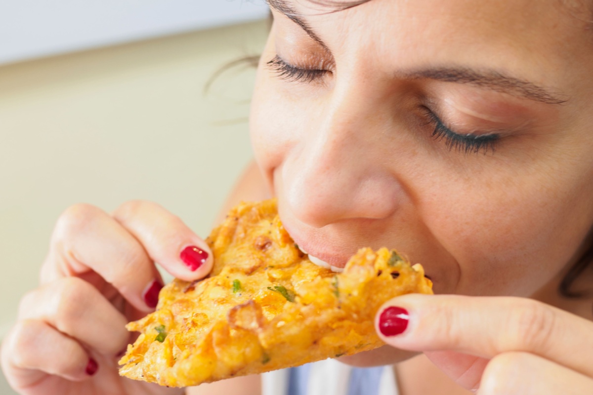 woman eating Spanish shrimp fritters