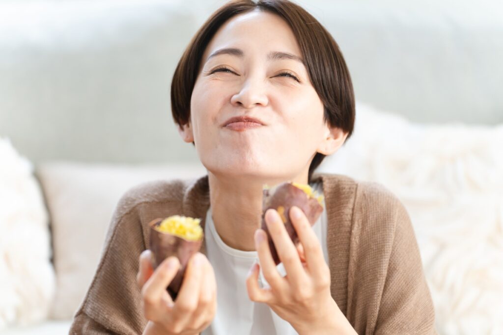 woman eating baked sweet potatoes