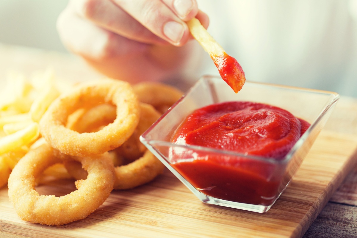 woman eating onion rings and ketchup