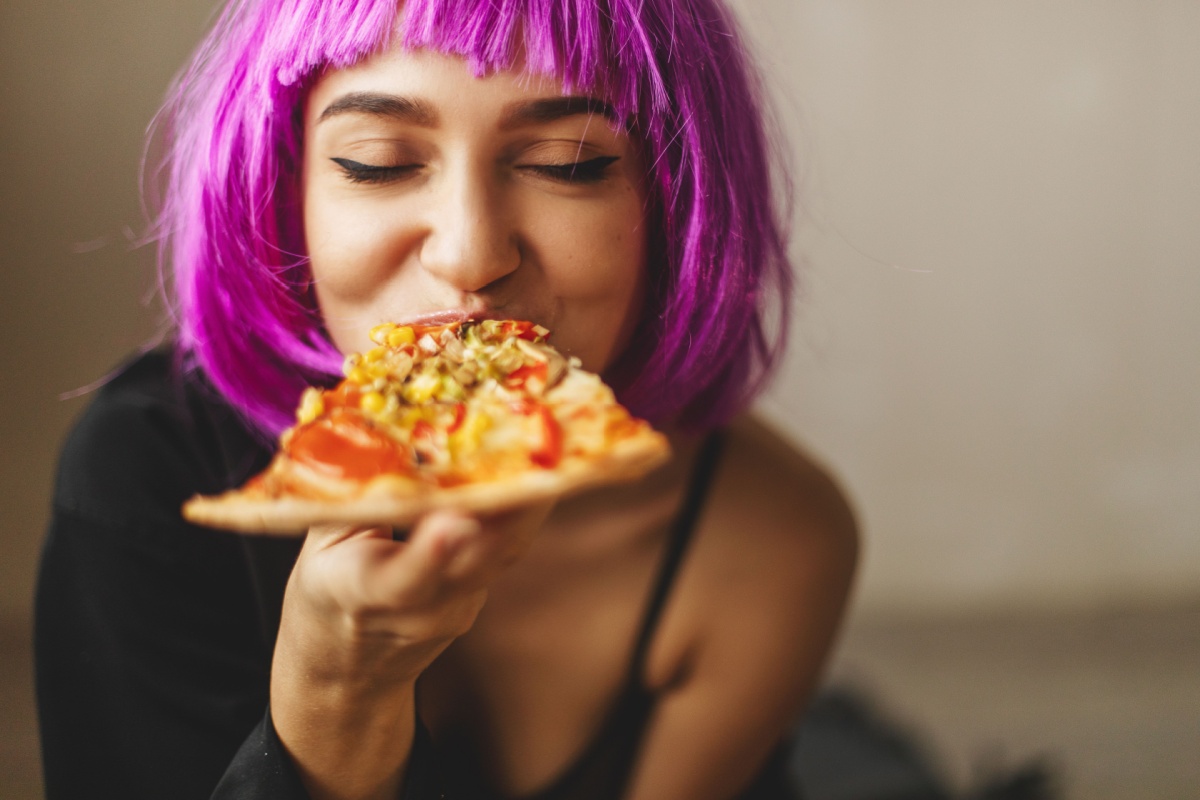 woman eating pizza purple hair