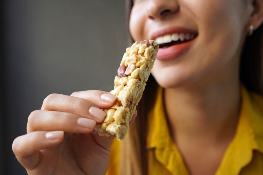 woman eating sugary granola bar