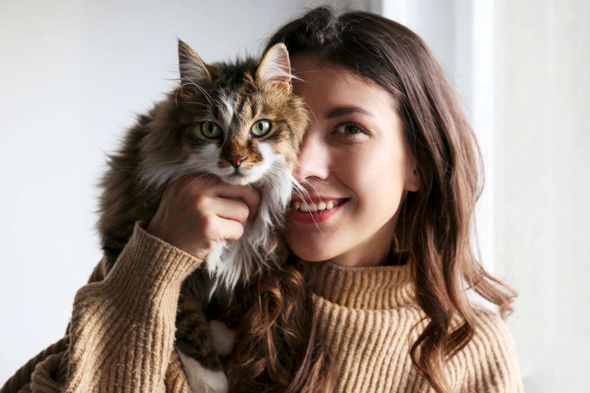 woman holding cat covering her face