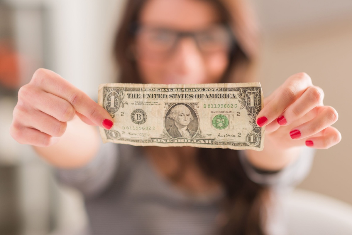 woman holding one dollar bill