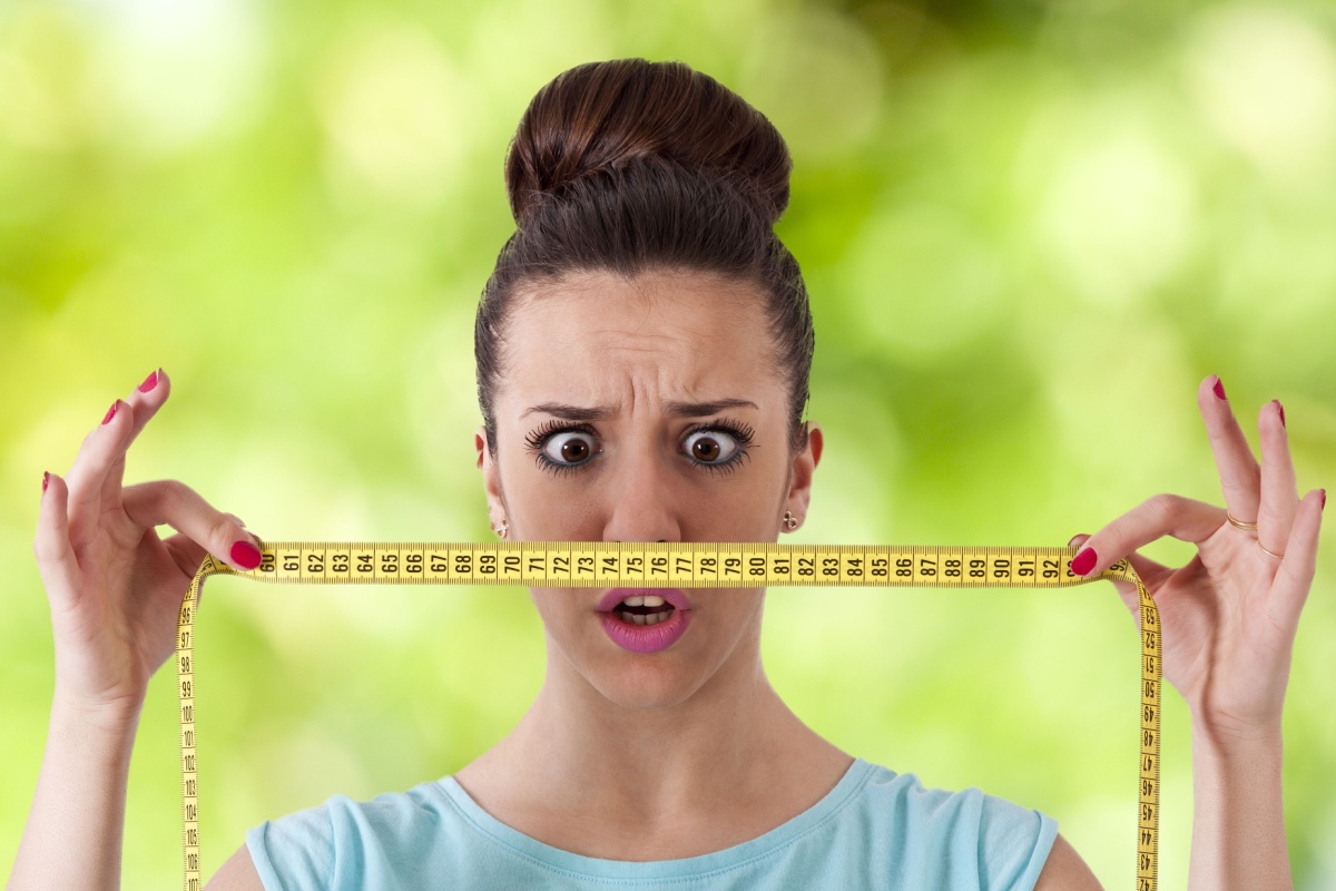 woman holding tape measure weight shock