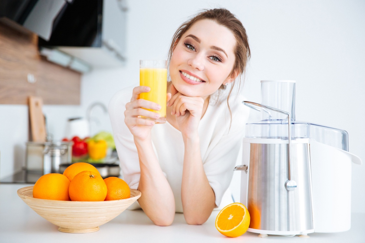 woman juicing fruit with juicer orange