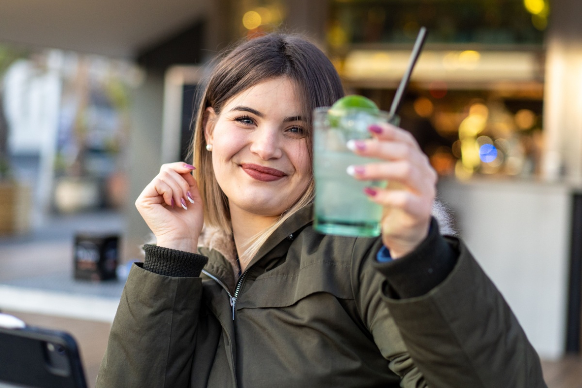 woman lifting drink mocktail cheers