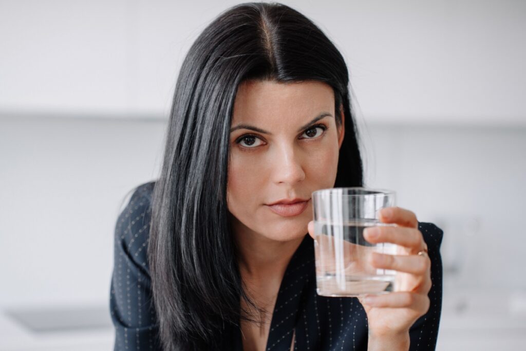 woman looking at camera with glass of water