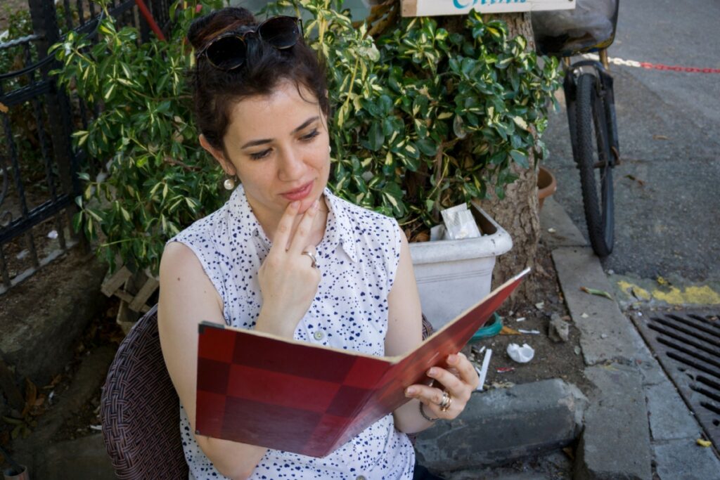 woman looking at menu outside cafe