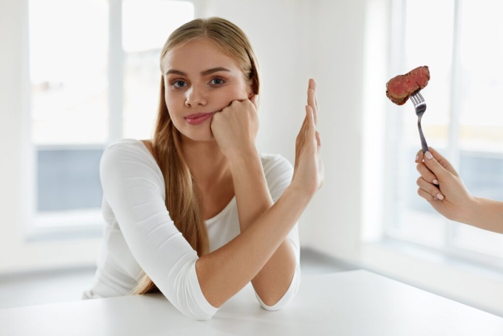 woman refusing meat on fork