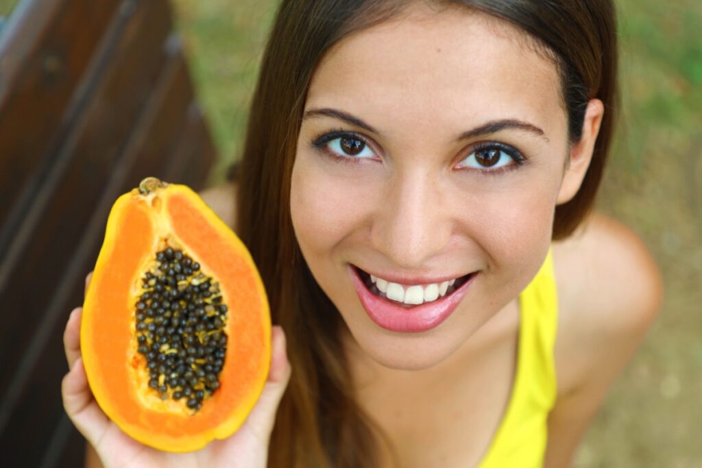 woman showing papaya seeds parasite cleanse fruit