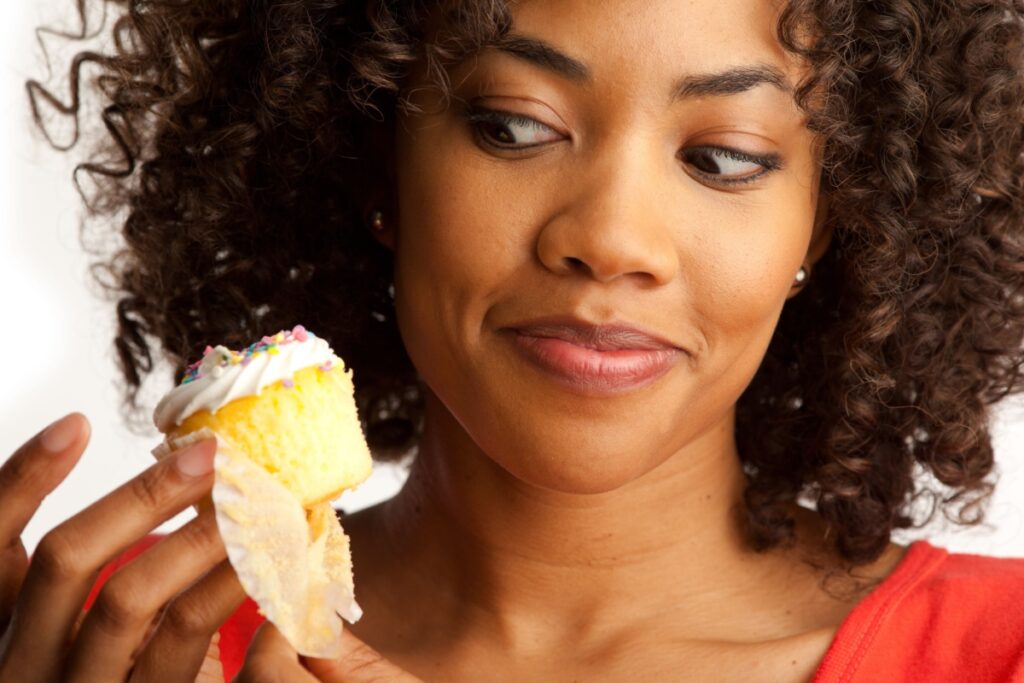 woman side eyeing a cupcake dessert