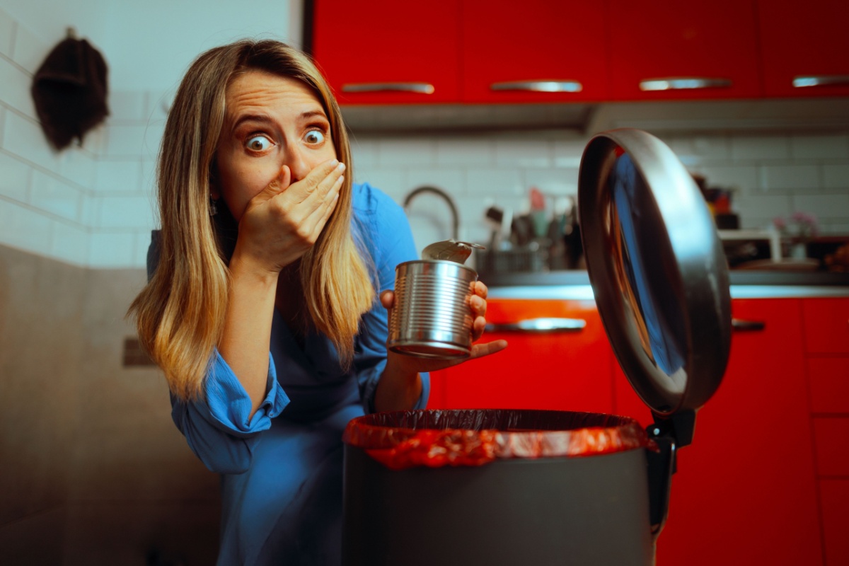 woman throwing away spoiled food trash