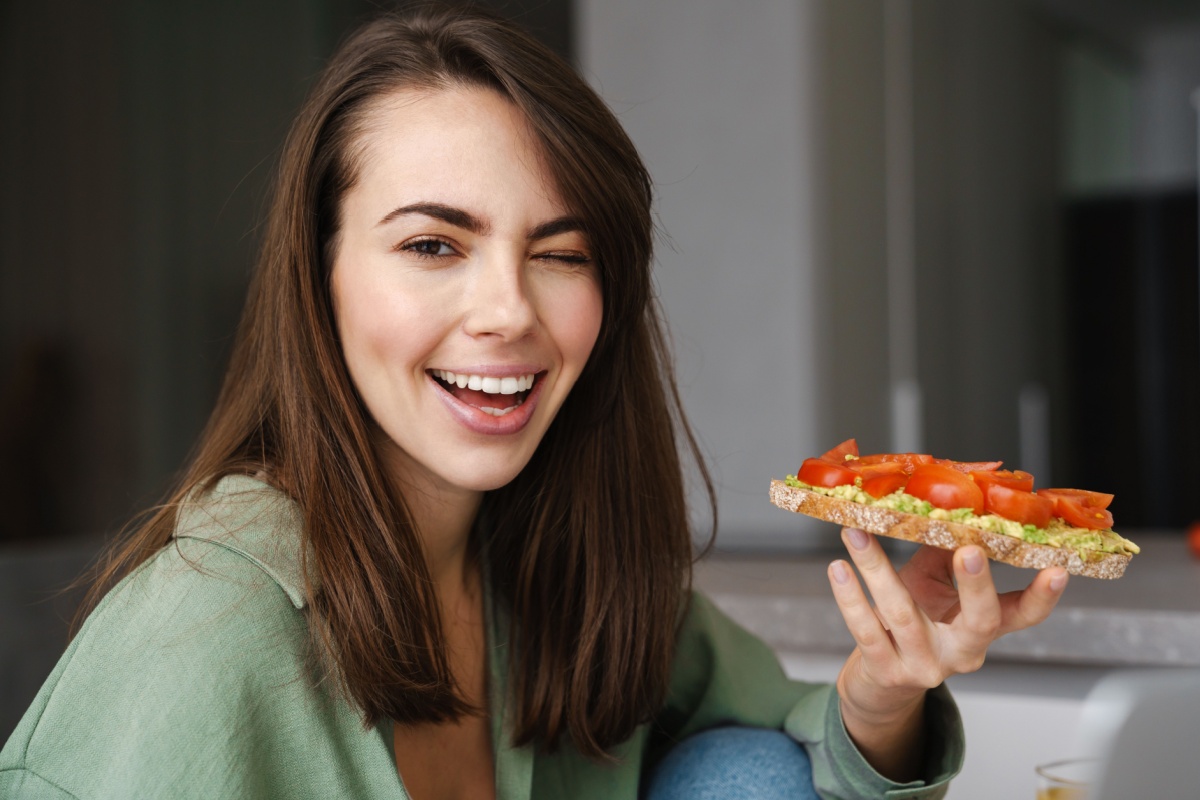 woman winking eating avocado toast