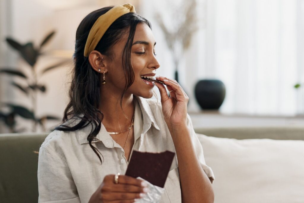 woman with chocolate bar on couch