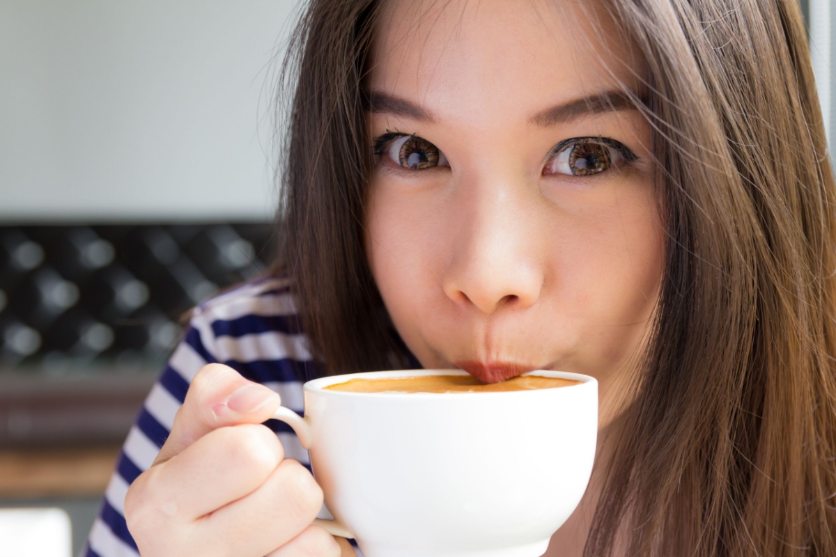 Asian woman drinking cappuccino espresso coffee