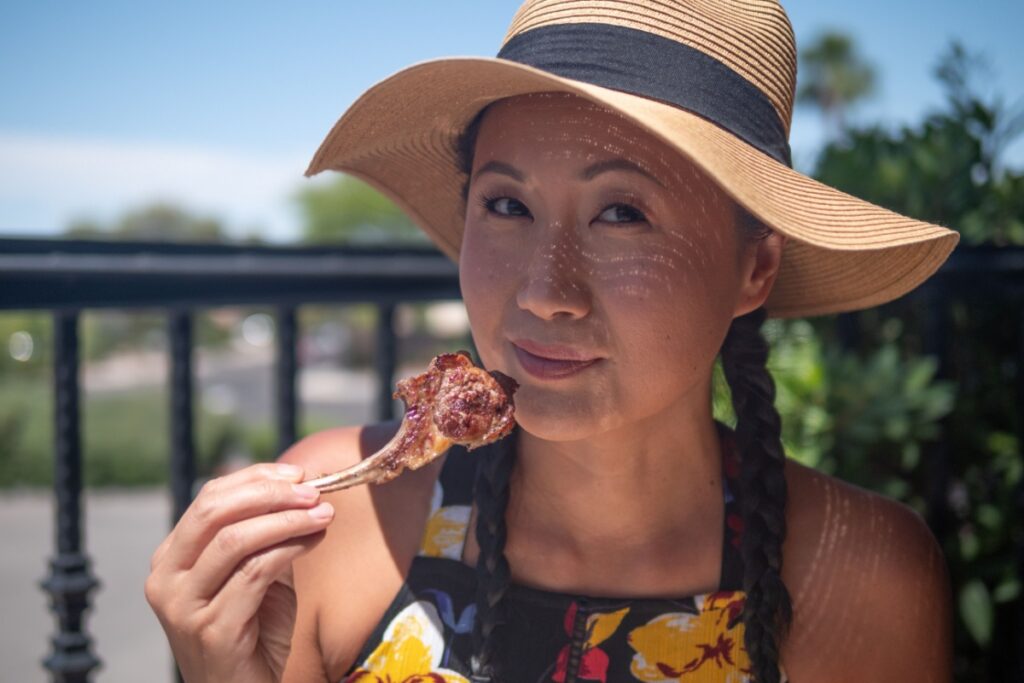 Asian woman eating grilled lamb chop 