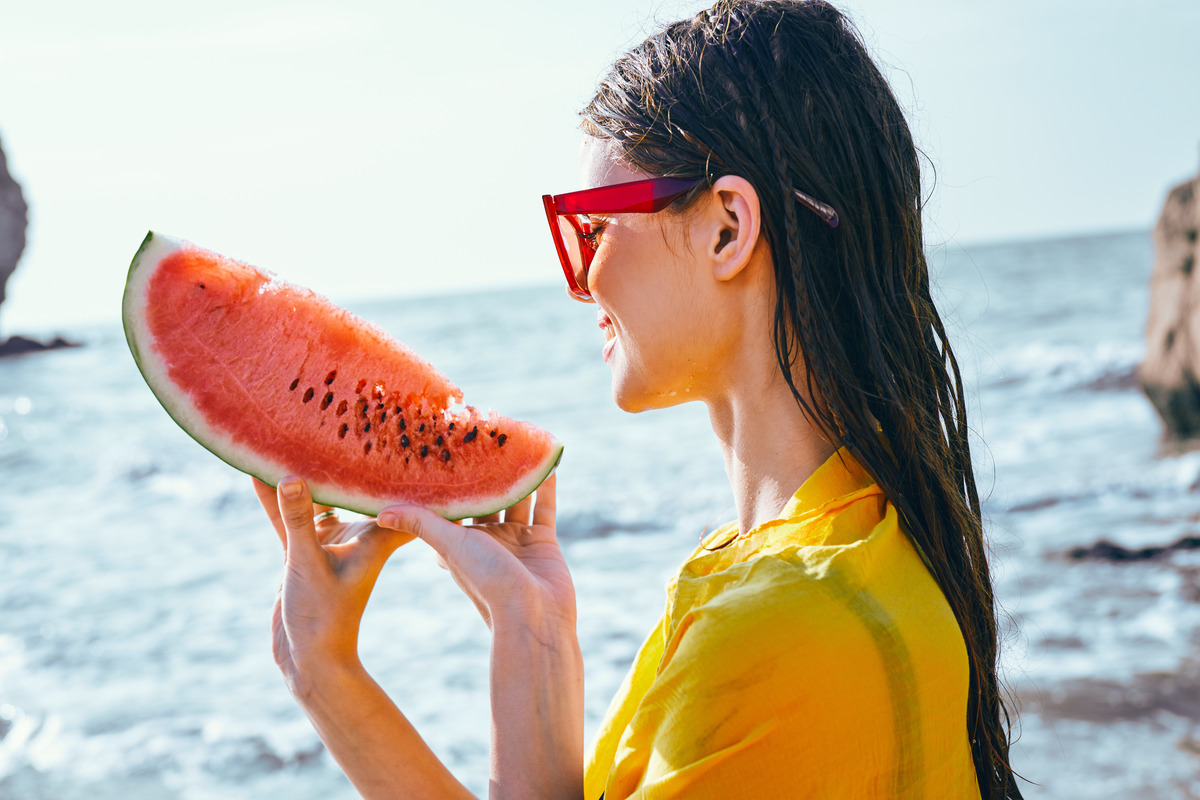 cheerful woman near the ocean with watermelon posing. High quality photo