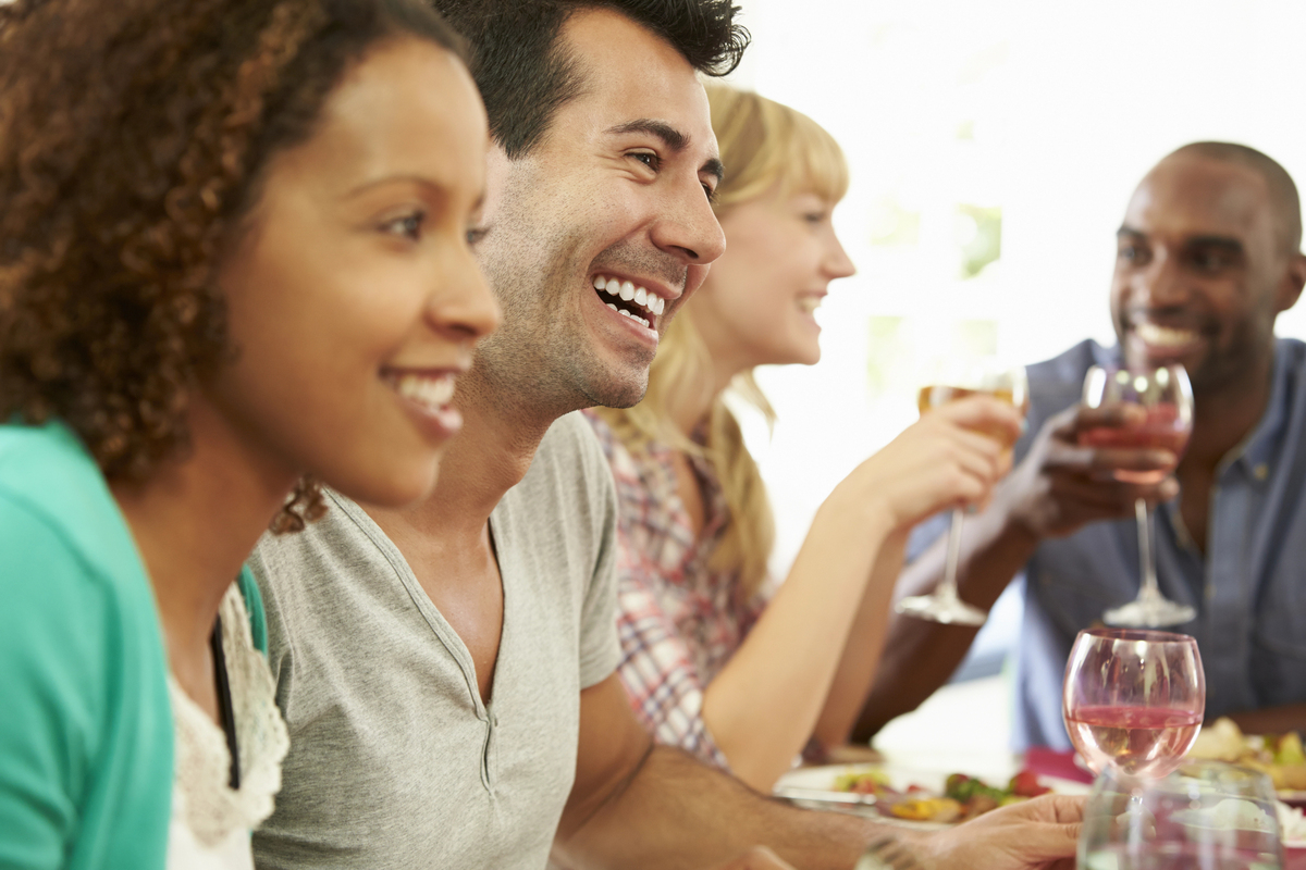 Friends Sitting Around Table Having Dinner