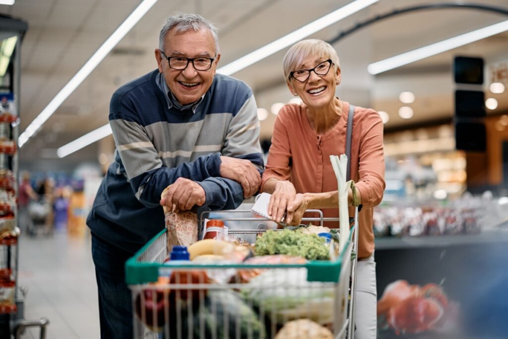 Happy mature couple buying groceries