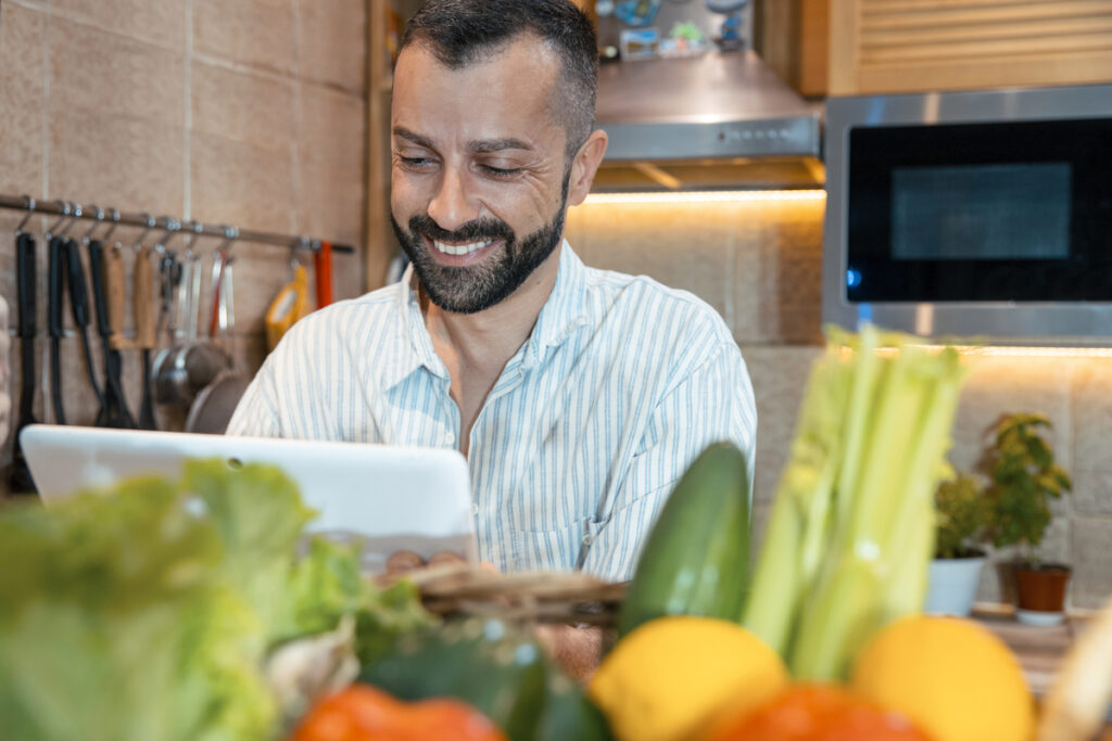 Man chef using tablet computer for online order.