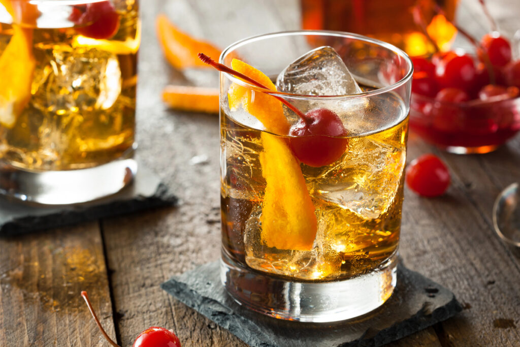 Homemade Old Fashioned Cocktail with Cherries and Orange Peel